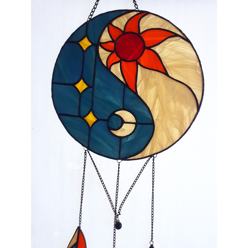 Stained glass Yin Yang suncatcher in art deco style in blue and yellow with sun and moon symbols on a white background.jpg