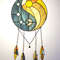 Stained glass dreamcatcher with blue and yellow Yin Yang symbol with hanging chains is lying on a white background.jpg
