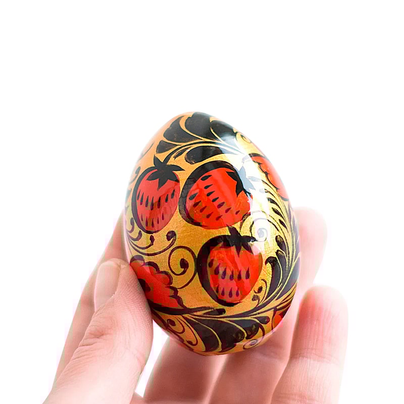 Russian Easter wooden painted egg Altai Khokhloma strawberries on a golden background