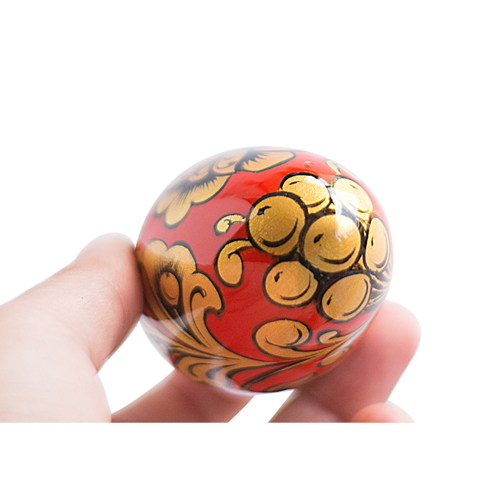 Russian painted egg Khokhloma gold flowers on a red background