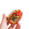 Russian painted egg Khokhloma gold flowers on a red background