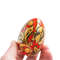 Russian painted egg Khokhloma gold flowers on a red background