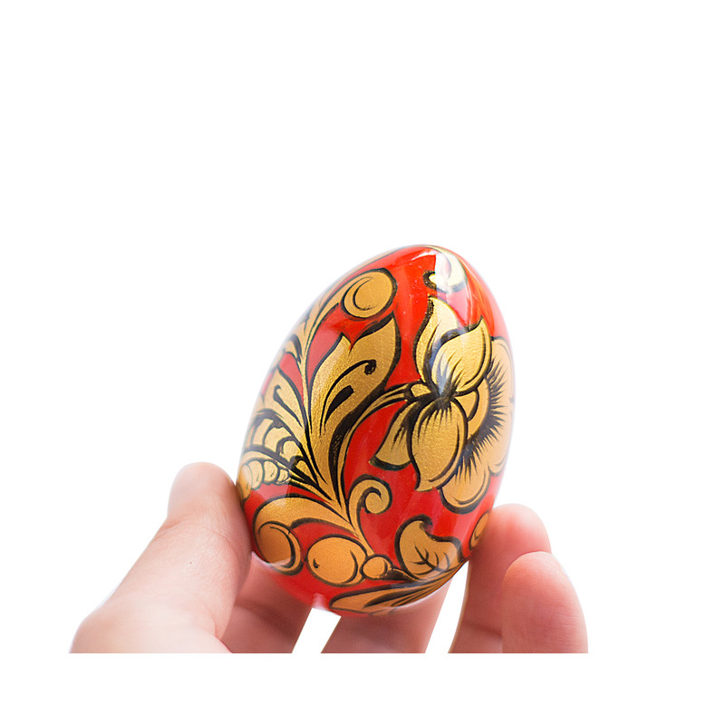 Russian painted egg Khokhloma gold flowers on a red background