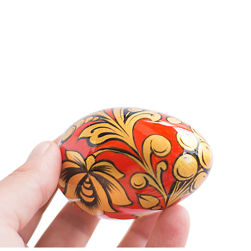 Russian painted egg Khokhloma gold flowers on a red background