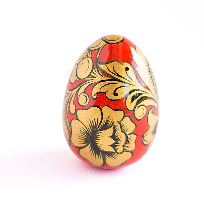 Russian painted egg Khokhloma gold flowers on a red background