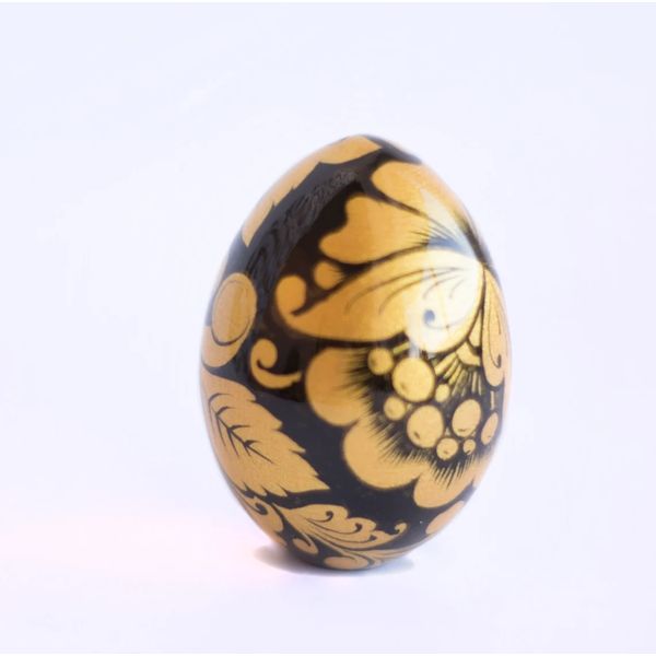 Russian painted egg Khokhloma gold flowers on a black background