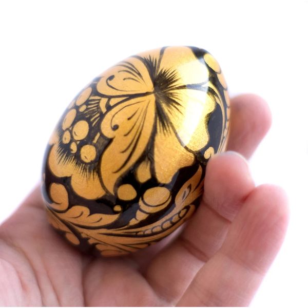Russian painted egg Khokhloma gold flowers on a black background