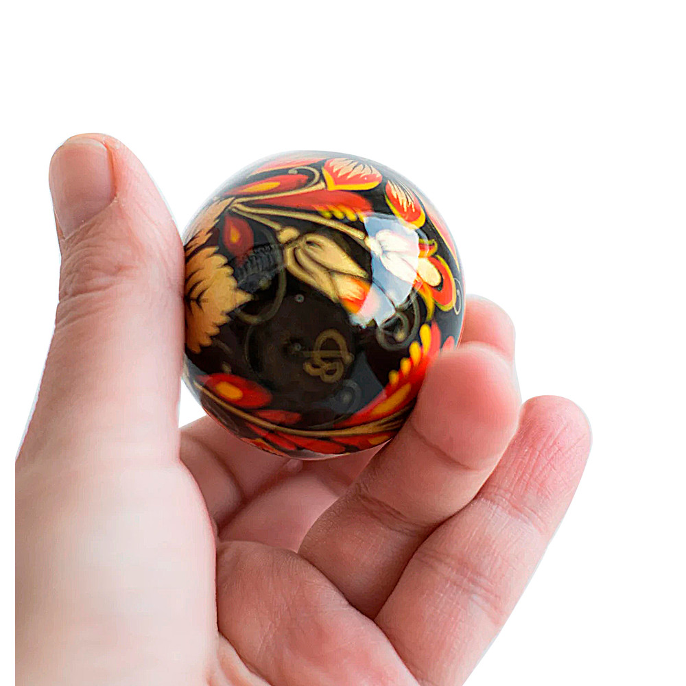 Russian painted egg Khokhloma golden flowers with red leaves on a black background
