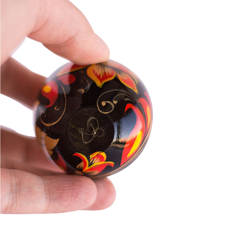 Russian painted egg Khokhloma golden flowers with red leaves on a black background