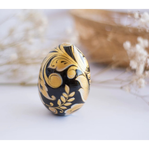 Russian painted wooden egg Khokhloma gold flowers on a black background