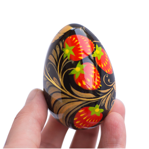 Russian wooden painted egg Khokhloma berry strawberry on a black background