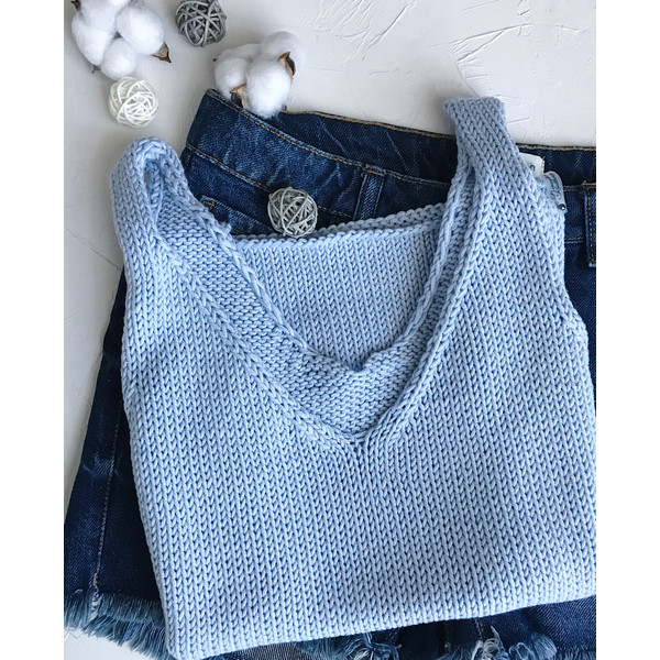 folded knitted t-shirt in blue lies on jeans.JPG