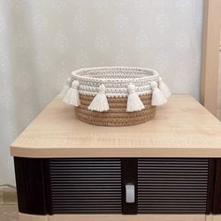 Interior handmade storage basket of jute and cotton with a wooden bottom.  Scandi, boho style.