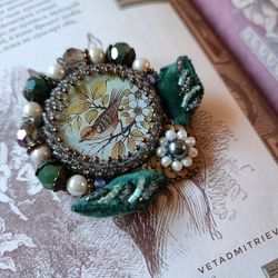 Order brooch, pendant in vintage style, with voluminous embroidery of leaves, with the image of a bird on a twig,