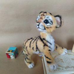 Tiger cub is a soft knitted toy. Cute toy amigurumi tiger. This tiger is a souvenir doll