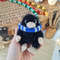 stuffed black niffler toy in slytherin scarf