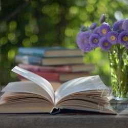 Still life photography with an open book and a bouquet of lilac asters. Digital flowers photo.