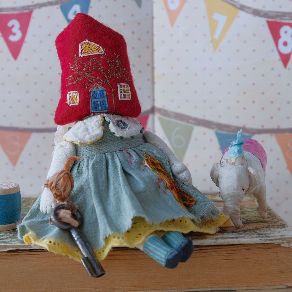 surreal doll sitting on a book old rusty key