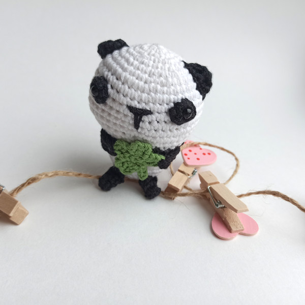 Amigurumi Panda Keychain on the white background with clothespins .jpg