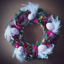 spring easter wreath made of willow vines, feathers, foam eggs, artificial flowers and branches.table decoration .