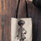 mockup-of-a-woman-s-hand-holding-a-tote-bag-against-a-wooden-background-26693 (8).png