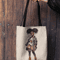 mockup-of-a-woman-s-hand-holding-a-tote-bag-against-a-wooden-background-26693 (25).png