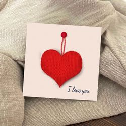 postcard with a knitted heart on a button