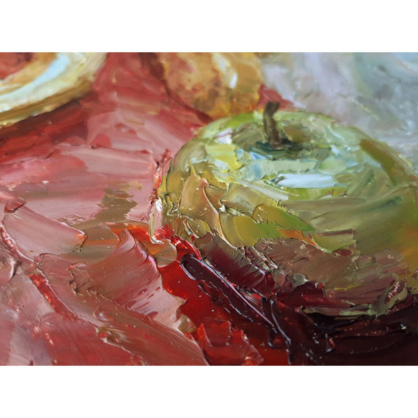 Fragment of a close-up painting green Apple on red.