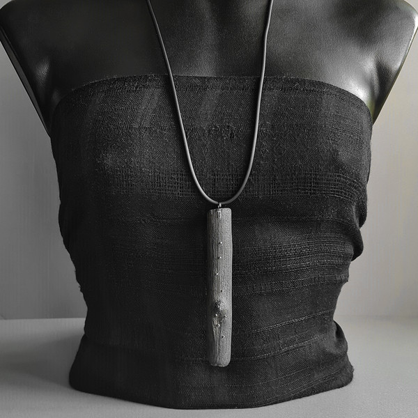 black pendant, wooden pendant, long pendant, rubber cord, silver drops, pendant necklace on a mannequin