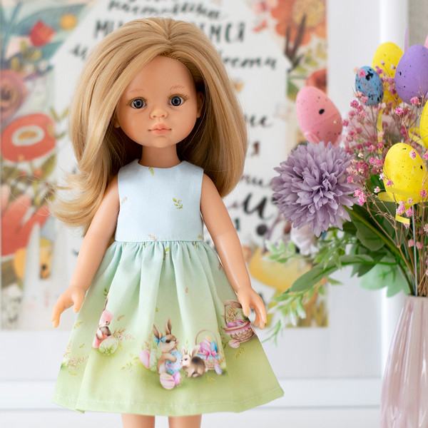 A 13-inch doll in an Easter dress with a print of eggs and Easter bunnies