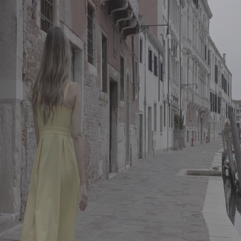 1080x1080 size woman-wearing-a-yellow-dress-and-walking-next-to-a-canal-and-buildings-convert-video-online.com_.00_00_07_24.Quadro002-1594x1062.jpg
