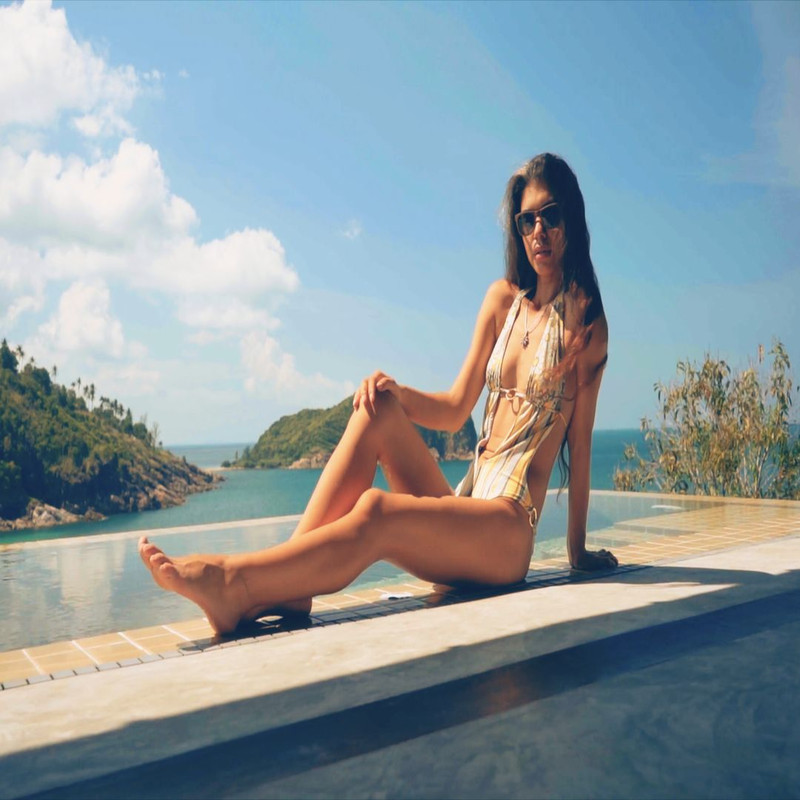 1080x1080 size model-posing-and-sitting-on-wall-by-ocean-convert-video-online.com_.00_00_00_00.Quadro001-1594x1062.jpg