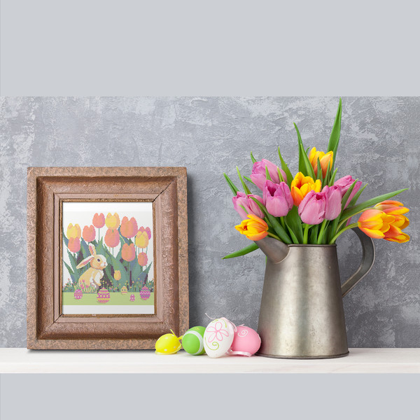 11 Cute Easter bunny in the spring green garden with red yellow pink tulips and multicolored Easter eggs and flowers cross stitch PDF pattern created for Creati