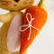 Felt Easter sand color bunny with long ears and bright orange carrot in his hand. Carrot close up.jpg