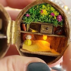 Tiny wooden dolls. Walnut shell diorama. Garden fairy house with wooden doll, tiny yellow duck and miniature book.