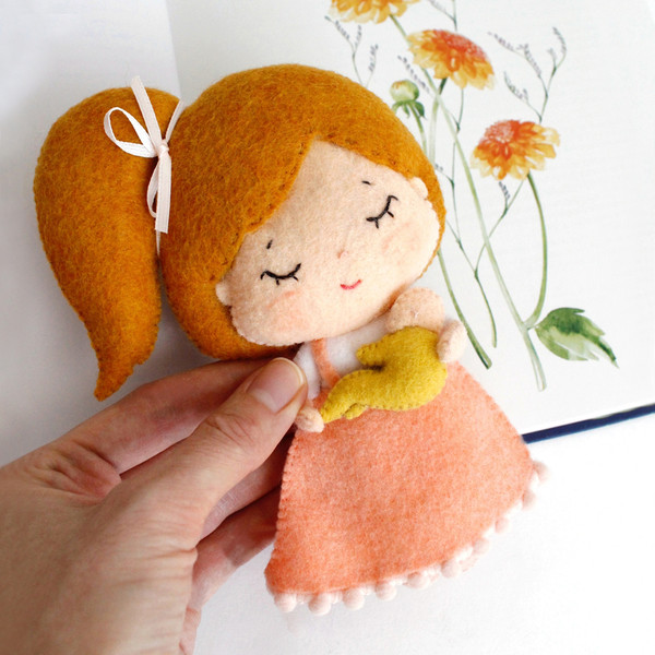 Felt Mother day toy gift - mama doll in the sundress with a baby in her hands, in the author's hand view near watercolor flowers