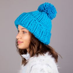 A bulky hat with a pompom. Turquoise color