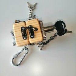 Little wood cube-chest, with locks and a light bulb. Entertaining toy for baby development, at home and on the road.
