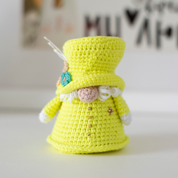 Crocheted gnome doll Queen Elizabeth II of Great Britain in a yellow outfit