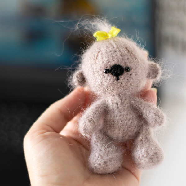 Cute small knitted bear in his hand