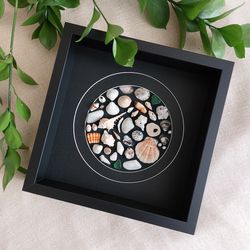 round collage of seashells, sea glass and pebbles. mosaic of shells in a frame with passe-partout. seashell art.