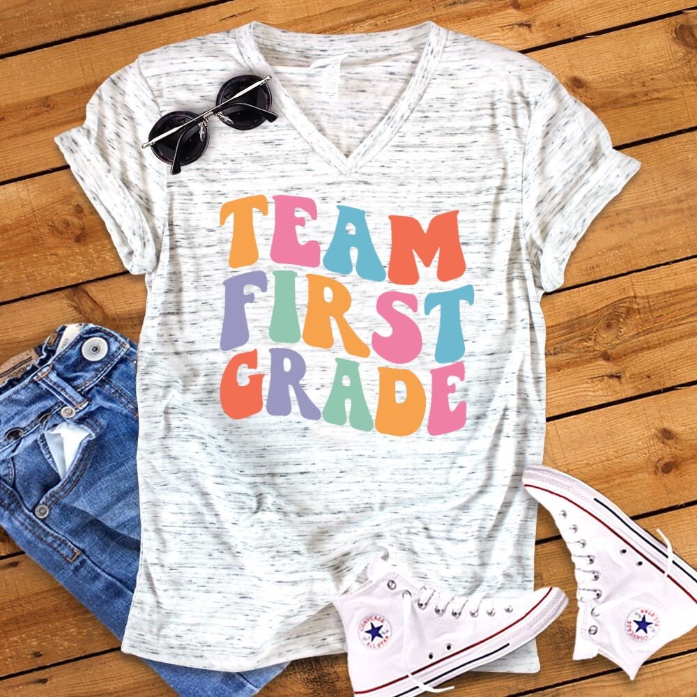 Team First Grade, Retro Back To School First Grade Teacher Novelty Graphic Unisex V Neck Graphic Tee T-Shirt - 1.jpg