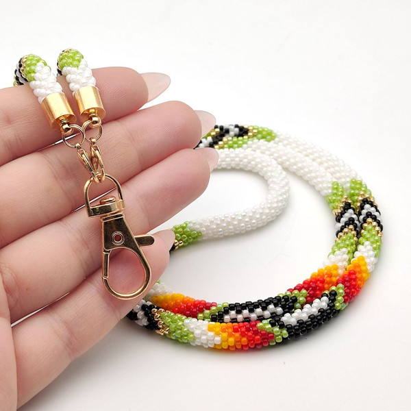 An artistic DIY kit for making lanyards, featuring a green ethnic design with crochet technique.