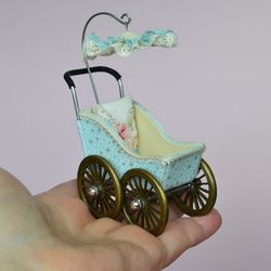 Miniature toy stroller for a little doll.  Pram for the little poopsie.