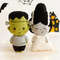 Felt toys Frankenstein and his bride in front of the painted Halloween decor, front view