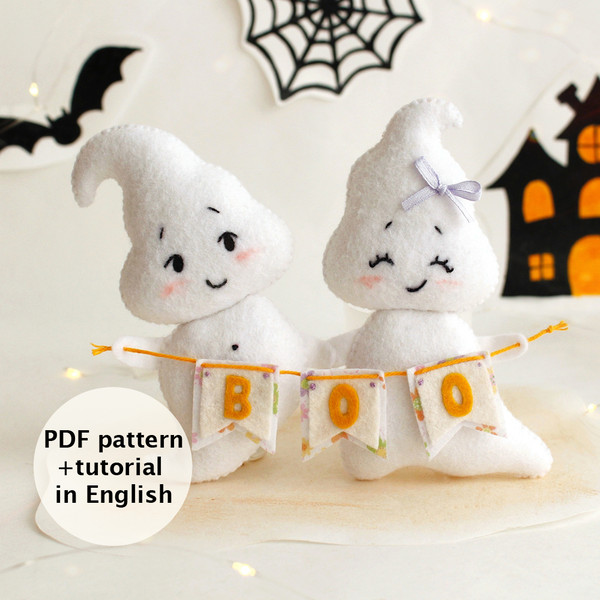 Felt ghost boy and girl with BOO garland in the hands standing against the background of painted Halloween decorations, front view