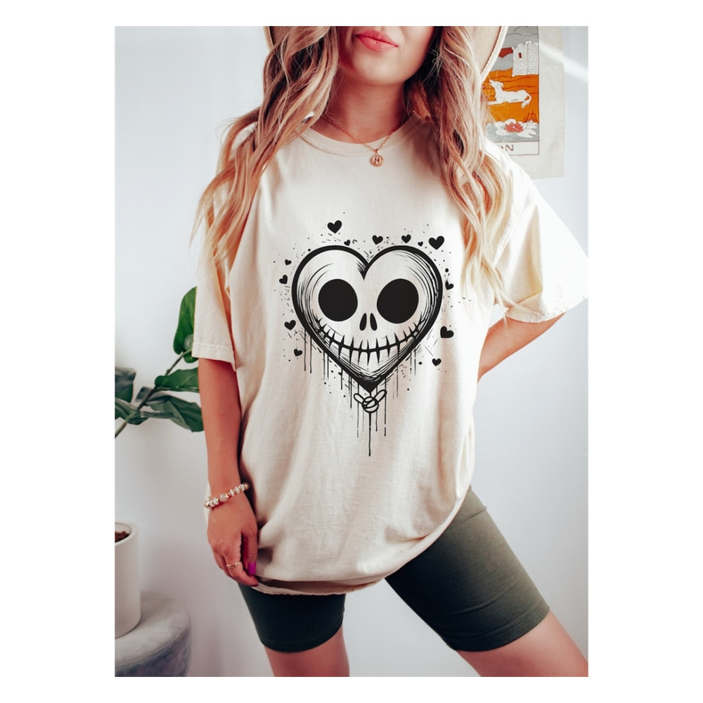 MR-129202382725-a-halloween-heart-of-a-skull-shaped-in-a-heart-shape-on-an-ivory-colored-tshirt-model-is-wearing-an-oversized-comfort-colors-ivory-tshirt-with-a