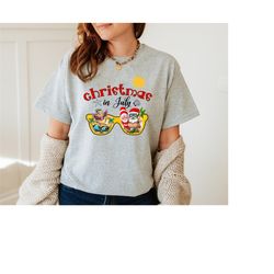 christmas in july shirt, sunglasses santa claus flamingo shirt, santa surfing tee, beach christmas shirt,xmas on the bea