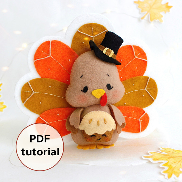 Felt Thanksgiving turkey with pie in the wings standing against the background of painted autumn leaves, front view