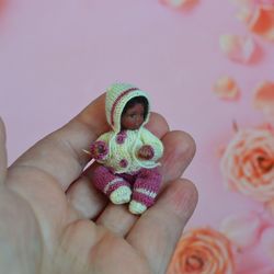 Miniature doll child in 12th scales. A baby for the dollhouse. Baby in a knitted suit.